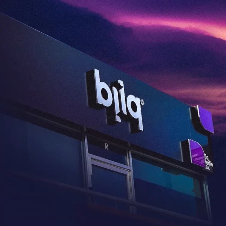 Fachada del estudio Bliq con su letrero iluminado al atardecer